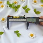 Lab certified Money Magnet Bracelet made with polished 8mm Green Aventurine, Citrine, and Pyrite beads, stretchable design placed on a soft fabric background