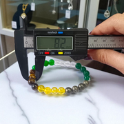 Lab certified Money Magnet Bracelet made with polished 8mm Green Aventurine, Citrine, and Pyrite beads, stretchable design placed on a soft fabric background