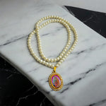 Moti mala with white pearls and Radha Krishna locket placed on a velvet cloth background