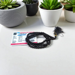 Natural Black Agate (Hakik) Mala made of 6mm smooth beads, coiled neatly with a Guru bead on a light background