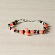 Natural Hessonite Bracelet with polished round beads on elastic cord, lab certified, placed on a wooden surface