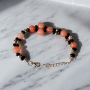 Natural Hessonite Bracelet with polished round beads on elastic cord, lab certified, placed on a wooden surface