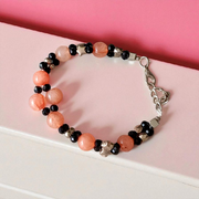 Natural Hessonite Bracelet with polished round beads on elastic cord, lab certified, placed on a wooden surface