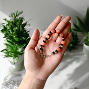 Natural Hessonite Bracelet with polished round beads on elastic cord, lab certified, placed on a wooden surface