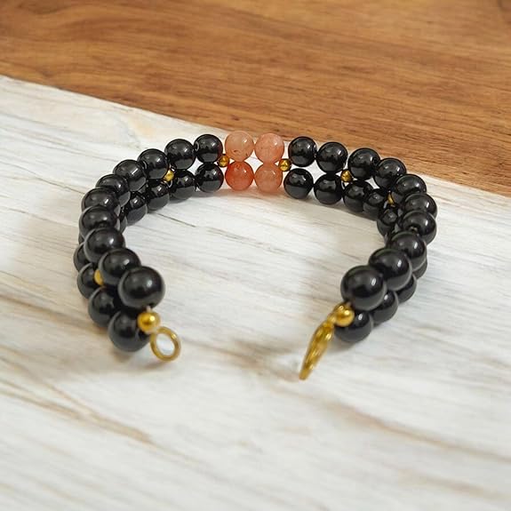 Natural Hessonite (Gomed) and Black Agate (Hakik) gemstone bracelet placed on a white background with a MALAWALA certification card beside it