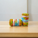 Pack of 2 multi-colored cotton moli threads with red, yellow, and green twists, neatly coiled for pooja use