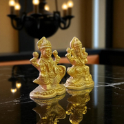 Pair of brass idols featuring Goddess Lakshmi and Lord Ganesha in intricate design, ideal for puja, gifting, and home decor