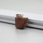 Polished deep red Almandine Garnet pendant with stainless steel chain, designed for men and women, displayed on a neutral surface