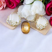 Polished natural brown Tiger Eye Stone with golden shimmer, placed on a white surface for healing and meditation purposes