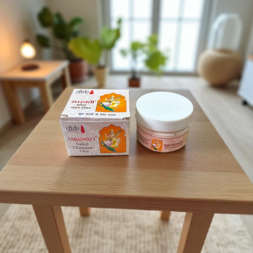 Pure white sandalwood paste (Safed Chandan Tilak) in a small container with creamy texture, ready for spiritual application