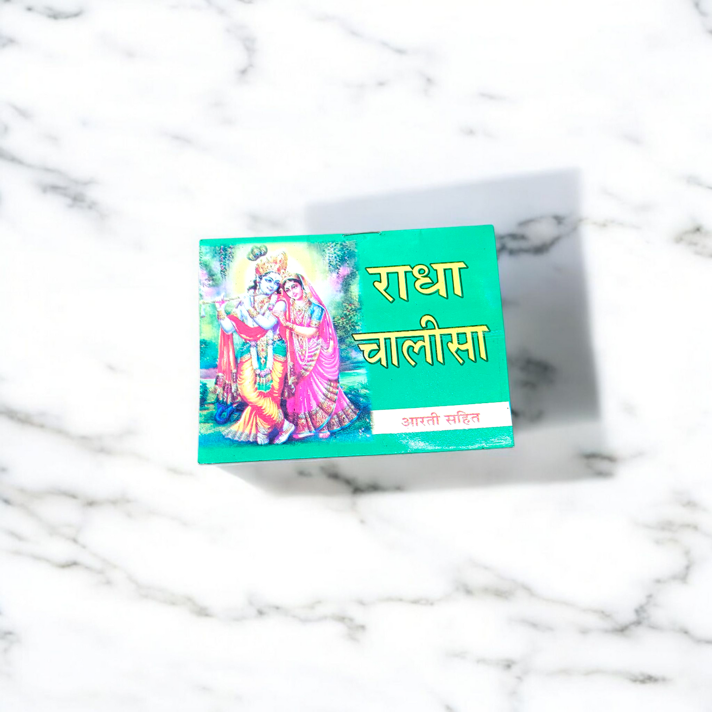 Radha Chalisa Hindi Book with devotional artwork of Radharani, placed beside incense and flowers in a prayer setting