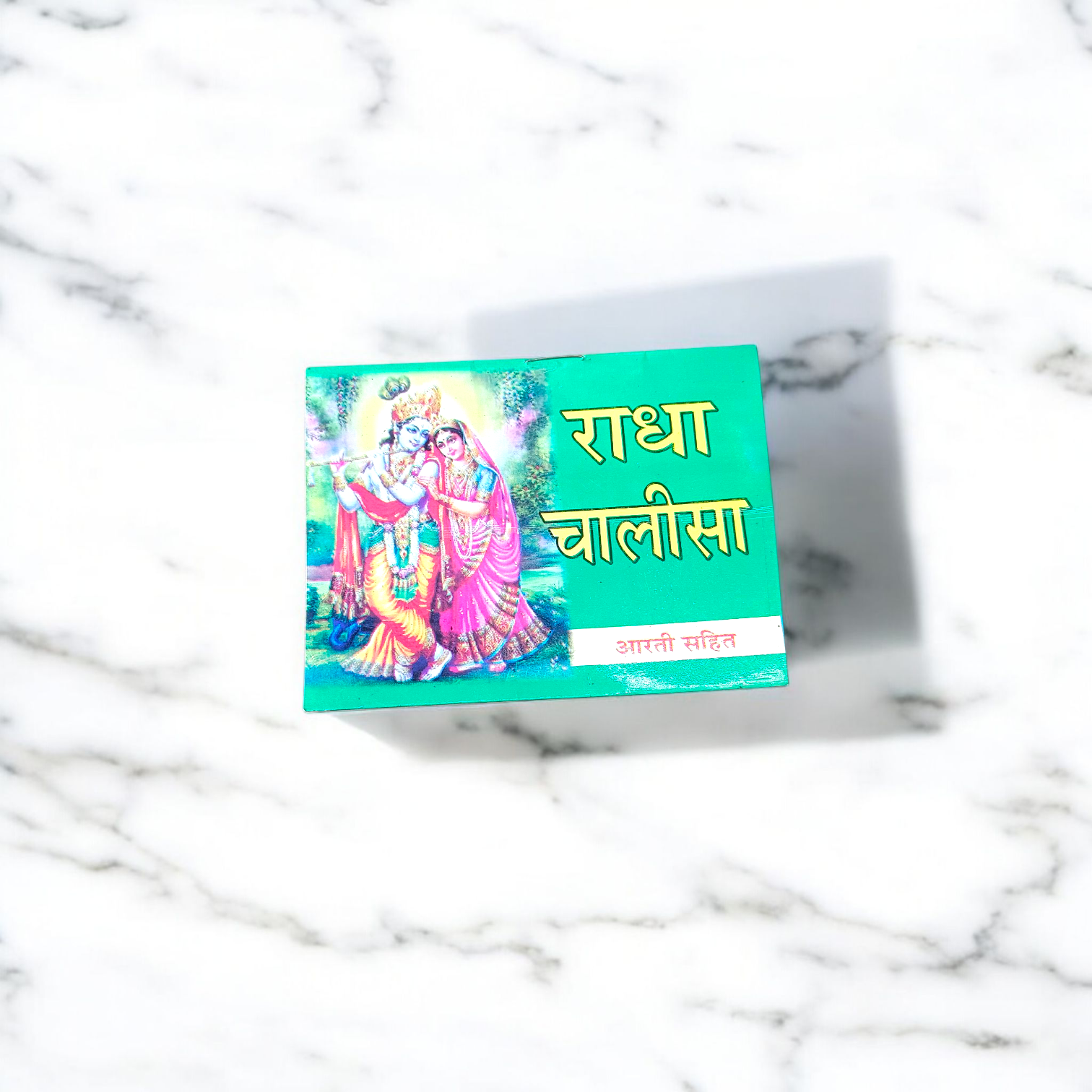 Radha Chalisa Hindi Book with devotional artwork of Radharani, placed beside incense and flowers in a prayer setting