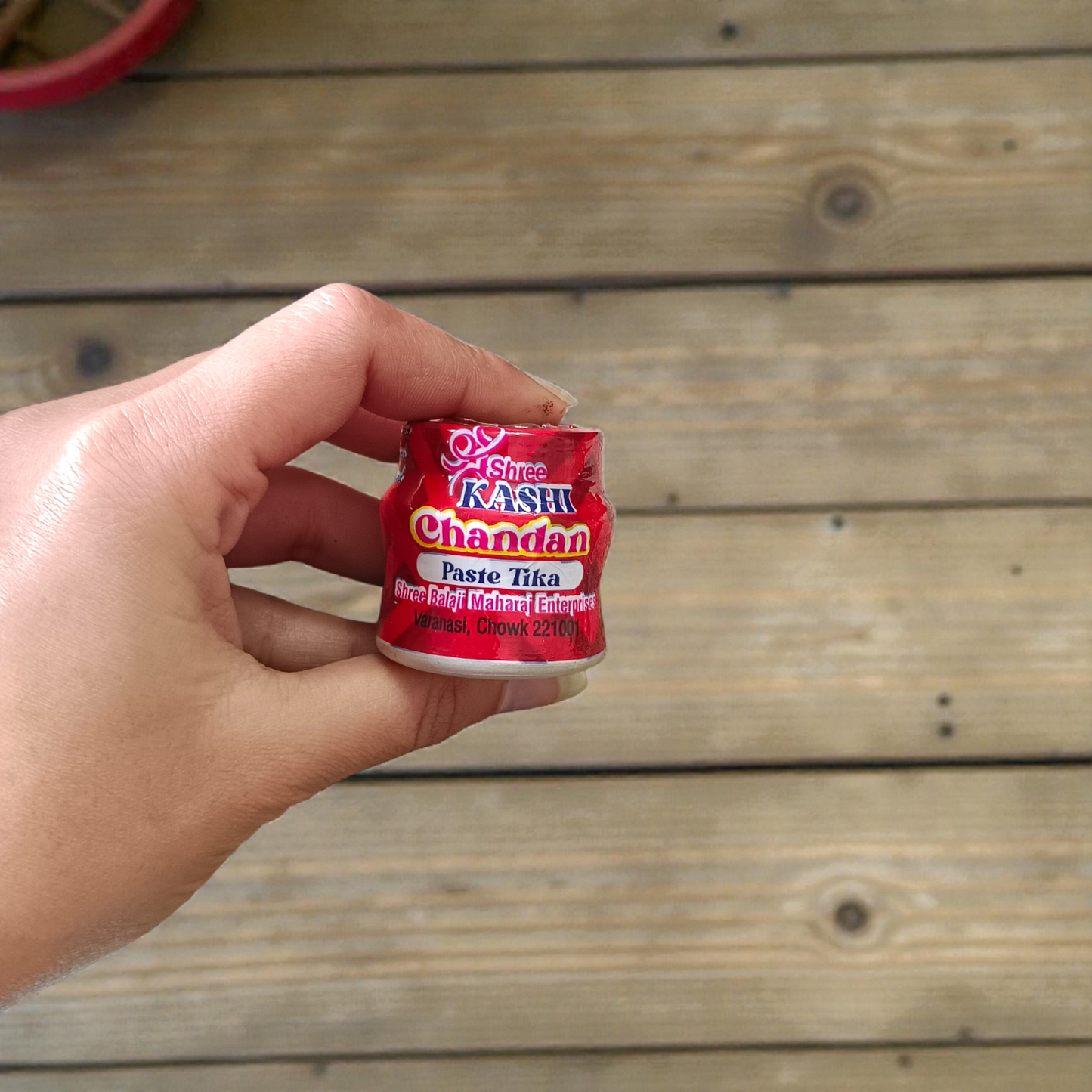 Red chandan paste container used for tilak, puja, and religious ceremonies