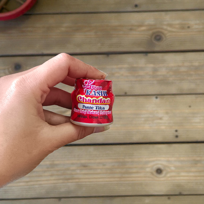 Red chandan paste container used for tilak, puja, and religious ceremonies