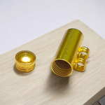 Set of 5 cylindrical pure brass taweez with Bhojpatra prayer sheets beside them on a white background