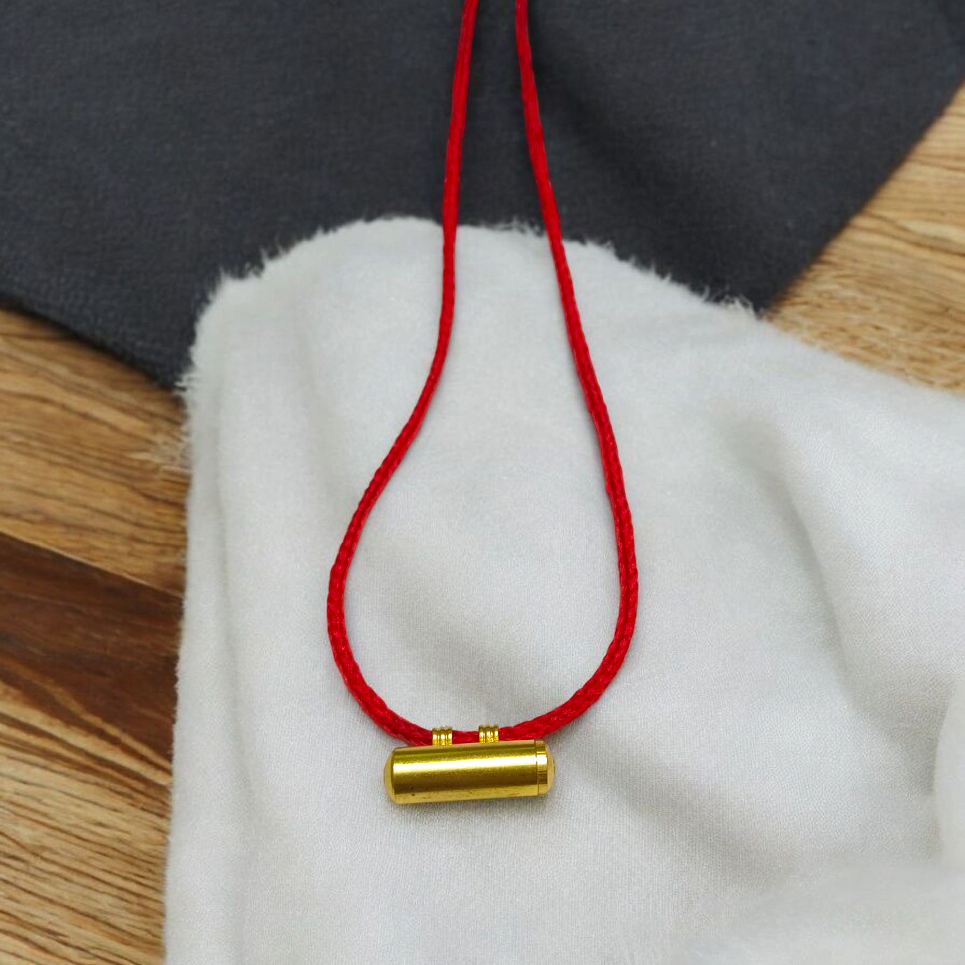 Set of 5 cylindrical pure brass taweez with Bhojpatra prayer sheets beside them on a white background