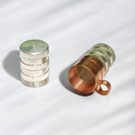 Set of 5 cylindrical pure copper and silver taweez placed beside Bhojpatra prayer sheets on a clean surface