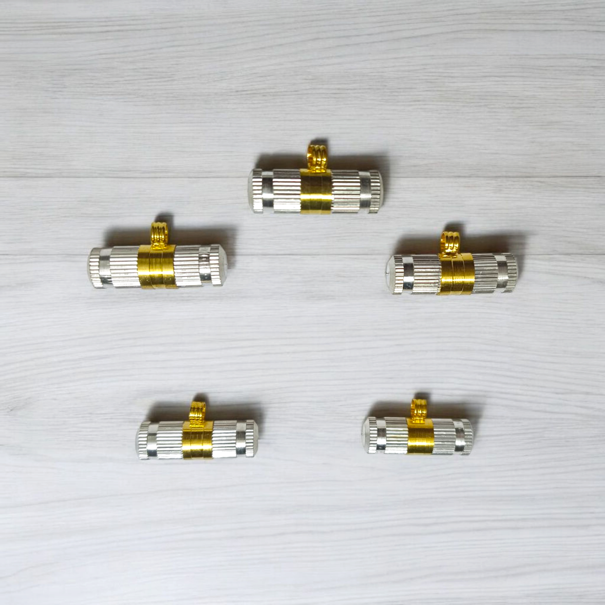Set of 5 silver and golden Taweez amulets with detailed craftsmanship and a rolled Bhojpatra sheet beside them