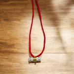 Set of 5 silver and golden Taweez amulets with detailed craftsmanship and a rolled Bhojpatra sheet beside them