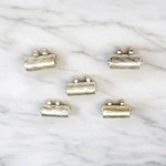 Set of five silver metal taweez amulets with Bhojpatra sheets, displayed against a white background