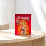 Shri Hanuman Bahuk Hindi Book with vibrant devotional artwork cover placed near Hanuman idol and diya