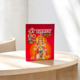 Shri Hanuman Bahuk Hindi Book with vibrant devotional artwork cover placed near Hanuman idol and diya