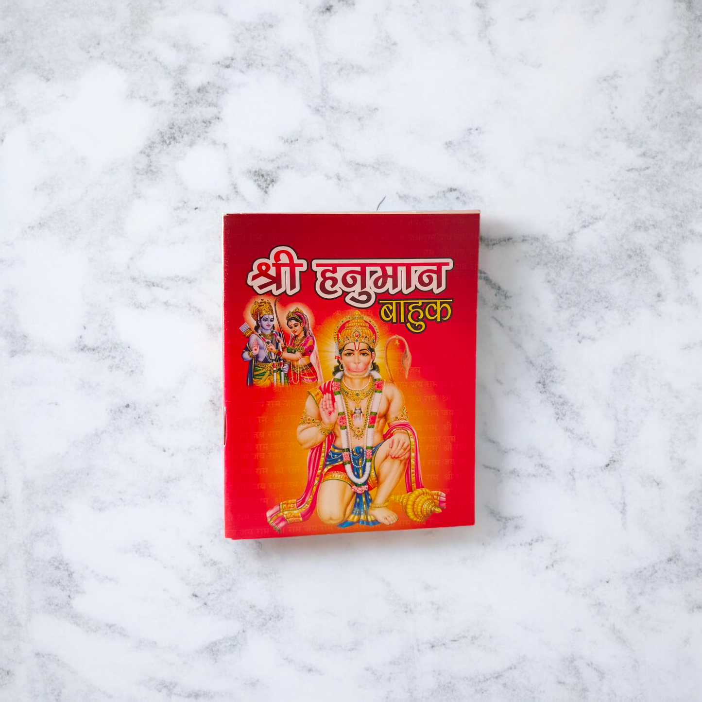Shri Hanuman Bahuk Hindi Book with vibrant devotional artwork cover placed near Hanuman idol and diya