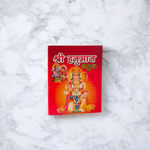 Shri Hanuman Bahuk Hindi Book with vibrant devotional artwork cover placed near Hanuman idol and diya