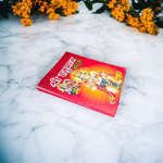 Shri Hanuman Bahuk Hindi Book with vibrant devotional artwork cover placed near Hanuman idol and diya