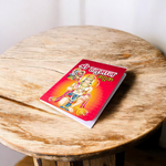 Shri Hanuman Bahuk Hindi Book with vibrant devotional artwork cover placed near Hanuman idol and diya