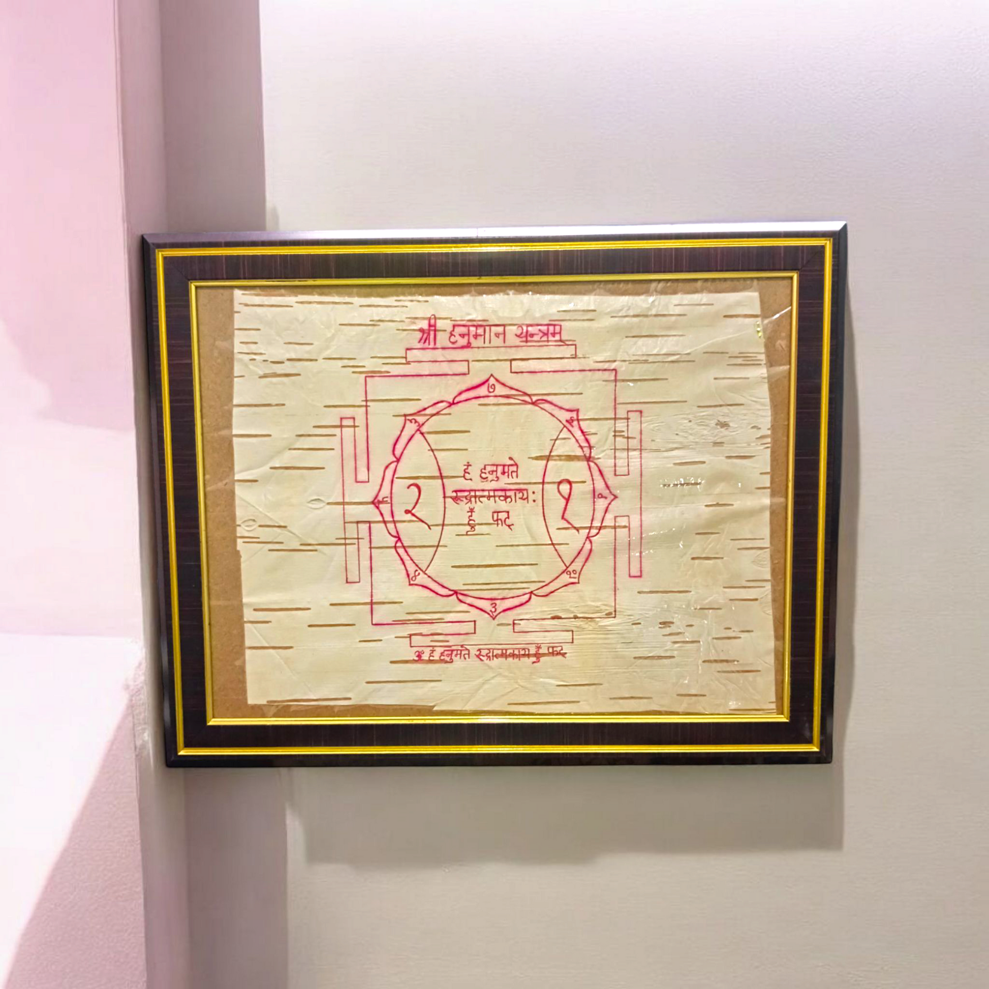 Shri Hanuman Yantra inscribed on Bhojpatra, framed in an antique wooden frame with glass cover, placed on a wooden altar.