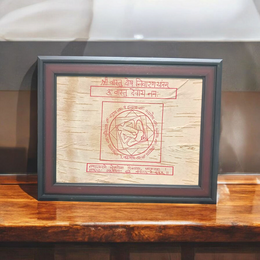 Shri Vastu Dosh Nivaran Yantra inscribed on Bhojpatra and framed in a premium wooden frame with a golden finish, placed on a decorative background