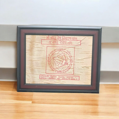 Shri Vastu Dosh Nivaran Yantra inscribed on Bhojpatra and framed in a premium wooden frame with a golden finish, placed on a decorative background