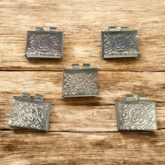 Silver square taweez set with Bhojpatra sheets arranged neatly on a decorative cloth background