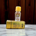 Small glass vial of 2ML Sandal Attar by Veena, MALAWALA brand, with golden cap and traditional label, placed on a wooden background with sandalwood chips