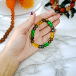 Stretchable 8mm bead Money Magnet Bracelet made of Green Aventurine, Citrine, and Pyrite crystals, lab certified, placed on a neutral background