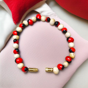 Stretchable bracelet made of natural red and white Gunja seeds, 5mm beads, displayed on a white background