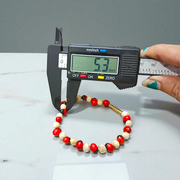 Stretchable bracelet made of natural red and white Gunja seeds, 5mm beads, displayed on a white background