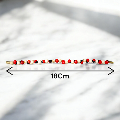 Stretchable bracelet made of natural red and white Gunja seeds, 5mm beads, displayed on a white background