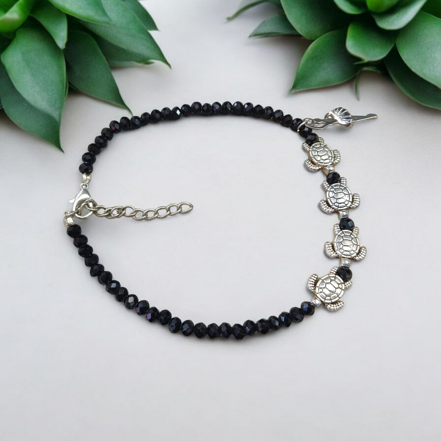 Stylish black crystal beads anklet featuring both Evil Eye and Tortoise charms, designed for unisex wear and spiritual protection