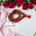 Traditional 5 Mukhi Rudraksha Kantha Mala with 108 beads, laid in a spiral on a wooden surface