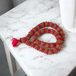 Traditional 5 Mukhi Rudraksha Kantha Mala with 108 beads, laid in a spiral on a wooden surface