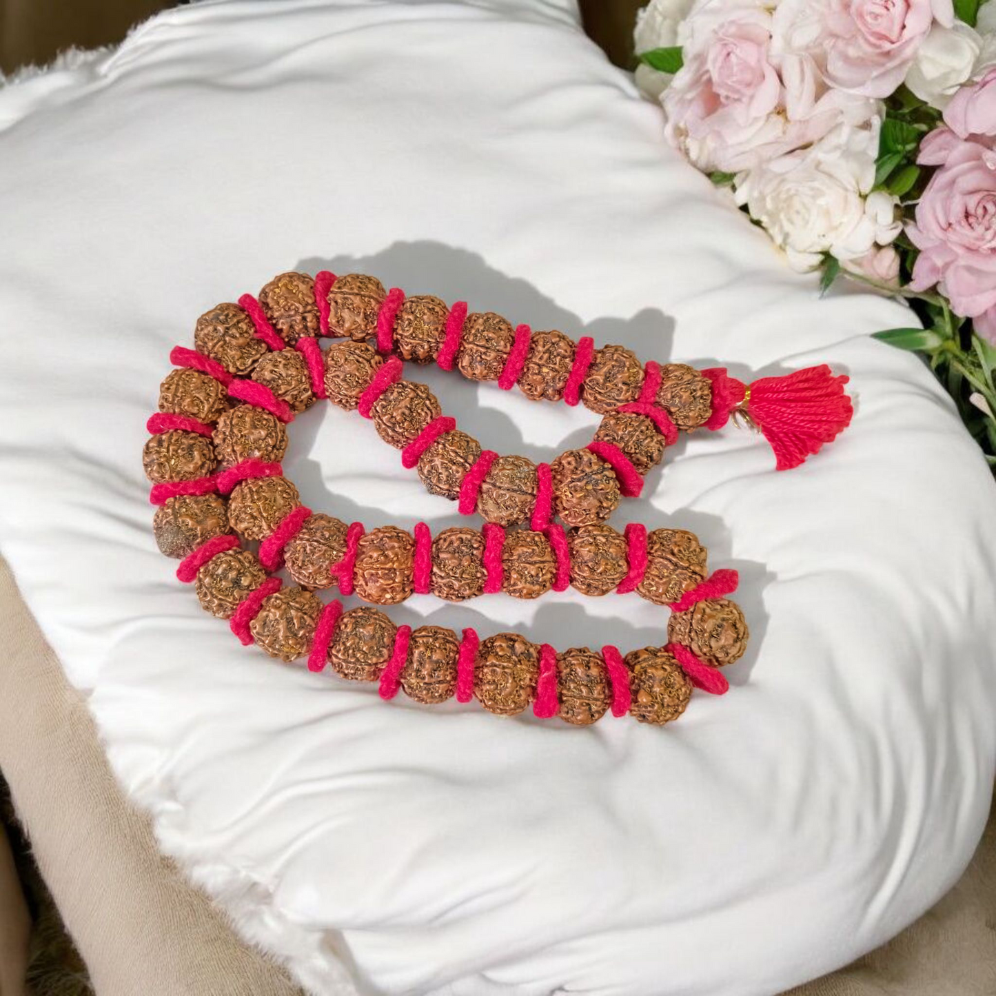 Traditional 5 Mukhi Rudraksha Kantha Mala with 108 beads, laid in a spiral on a wooden surface
