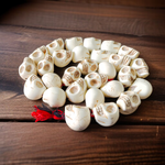 Traditional Nar Mund Mala with skull-shaped beads tied in red thread, arranged on a dark spiritual altar cloth