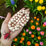 Traditional Nar Mund Mala with skull-shaped beads tied in red thread, arranged on a dark spiritual altar cloth