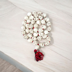 Traditional Nar Mund Mala with skull-shaped beads tied in red thread, arranged on a dark spiritual altar cloth