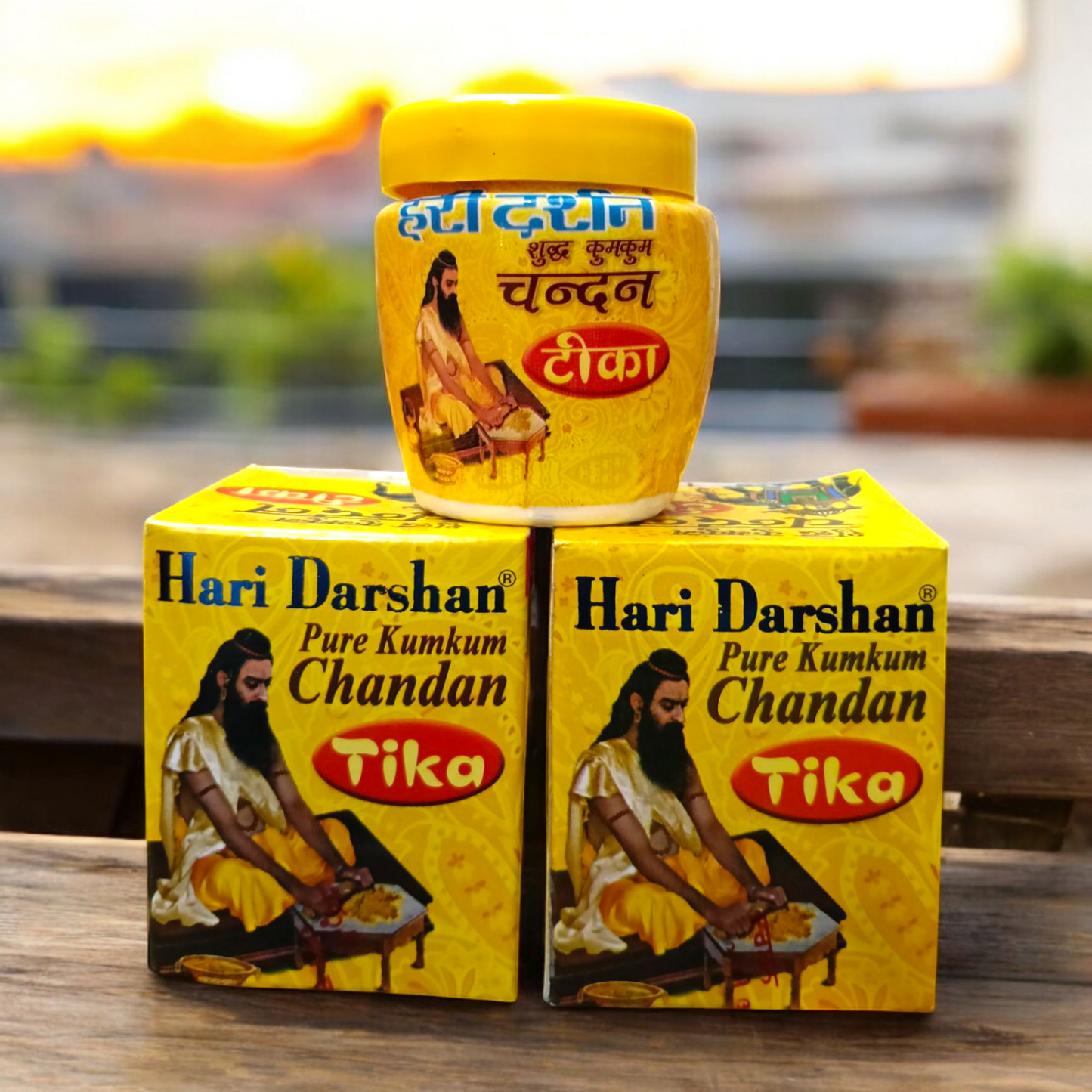 Two plastic containers of Hari Darshan Kumkum and Chandan Tilak with vibrant red and beige paste used for religious markings