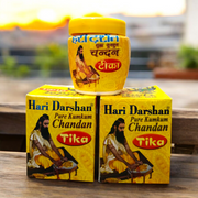 Two plastic containers of Hari Darshan Kumkum and Chandan Tilak with vibrant red and beige paste used for religious markings