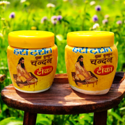 Two plastic containers of Hari Darshan Kumkum and Chandan Tilak with vibrant red and beige paste used for religious markings