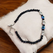 Unisex black crystal beads anklet featuring protective Evil Eye and lucky Fish charms, handcrafted for spiritual style and daily wear